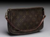 a louis vuitton cross body bag on a grey background