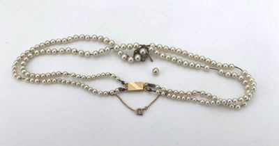 a white pearl necklace with a silver clasp and a heart charm