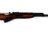 un fusil sur fond blanc, avec un pistolet au premier plan et un couteau au premier plan