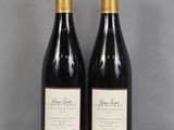 two bottles of wine sitting on top of a table next to each other