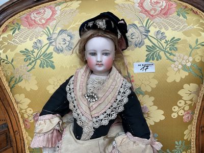 a doll that is sitting on a chair in a room