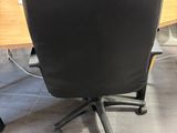 a black office chair sitting in front of a computer desk