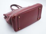 burgundy leather handbag on white background