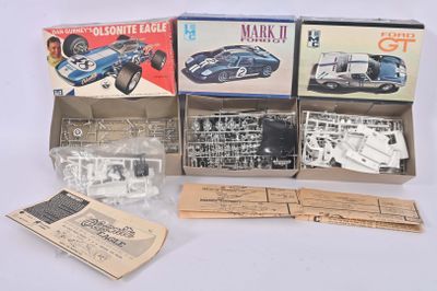 une boîte contenant un assortiment de modèles réduits de voitures, posée sur une table