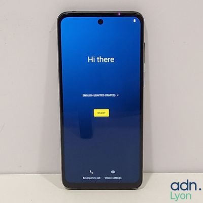 un gros plan d'un téléphone portable posé sur une table, dont l'écran est bleu