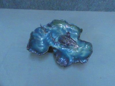une broche en forme de fleur bleue et verte sur un fond blanc