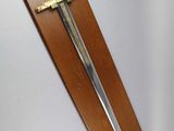 wooden plaque with a sword mounted on it on a wall