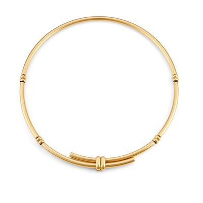 a gold bang bracelet with a beaded clasp on a white background