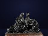 une statue en bronze représentant un homme et une femme sur un bateau