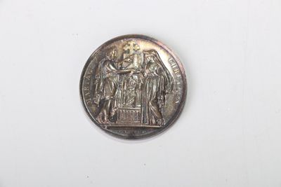 une pièce d'argent sur laquelle figure l'image d'un groupe de personnes