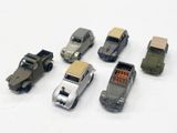 six petites voitures alignées sur une surface blanche