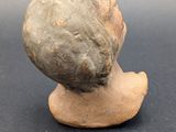 an image of a clay head of a woman on a black surface