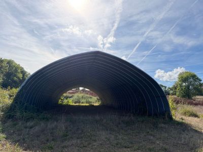 a large metal structure sitting in the middle of a field