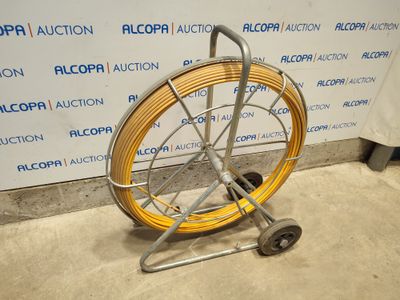 un tuyau jaune posé sur un chariot devant un mur