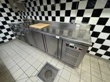 a kitchen with a checkered wall and stainless steel counter tops
