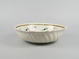 a white bowl with a yellow rim and blue flowers on it