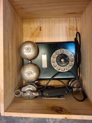 une boîte en bois contenant un téléphone et d'autres objets