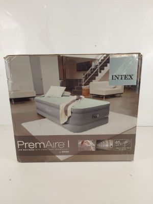the box of the inflatable air mattress is open on the floor
