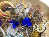 a wooden bowl filled with assorted jewelry and bracelets