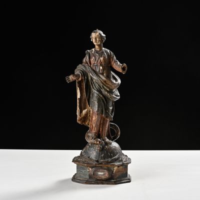 an old statue of a woman holding a basket on top of a table