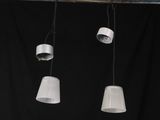 trois lampes blanches suspendues au plafond sur fond noir