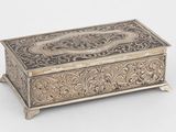 une boîte ancienne en argent avec un motif floral sur le couvercle