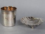 une coupe en argent et une assiette en argent posées sur une table