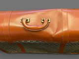 a brown leather case with a handle on a gray surface