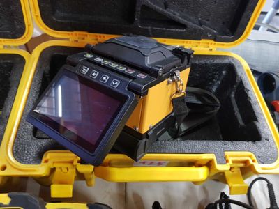 a yellow case with a monitor and other items in it