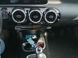 someone is sitting in the driver ' s seat of a car with their foot on the steering wheel