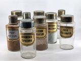 several jars of spices are lined up on a white surface