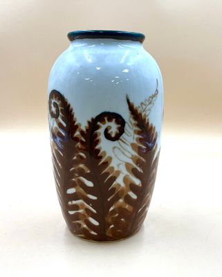 un vase bleu orné d'un motif marron et blanc