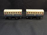 two toy trains are sitting side by side on a black surface