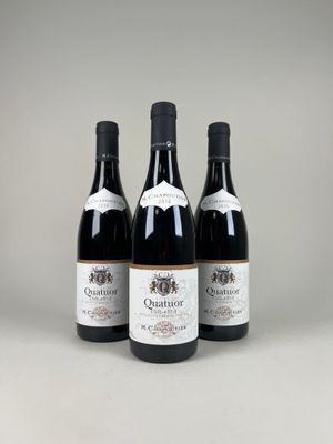 three bottles of red wine sitting on top of a table