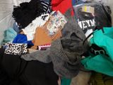 a pile of clothes that is on a bed