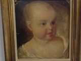 painting of a baby in a gold frame on a white wall
