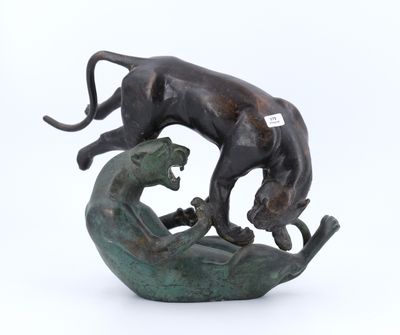 statue représentant un chat et un chien posés sur un rocher, sur fond blanc