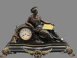a statue of a woman sitting on top of a clock