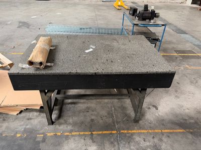 une table sur laquelle est posé un rouleau de papier, dans un entrepôt