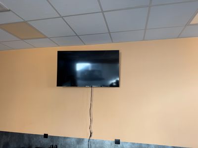 une télévision à écran plat fixée au mur au-dessus d'un lavabo