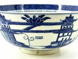 a blue and white bowl on a white surface