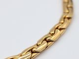 a close up of a gold chain on a white surface