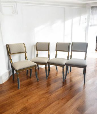 four chairs sitting in a row in the middle of a room