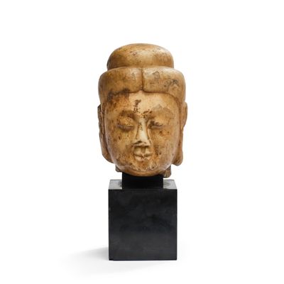 une image représentant une tête sculptée posée sur un socle noir
