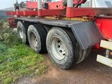 un gros camion rouge garé sur le bord de la route