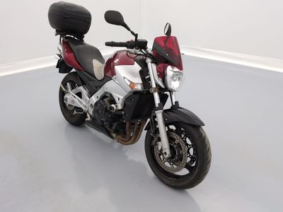 une moto rouge et blanche garée dans une pièce blanche