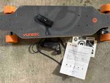 un skateboard posé par terre à côté d'un chargeur