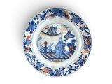 une assiette bleue et blanche ornée d'un motif bleu et orange