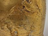 a gold vase that is sitting on a table