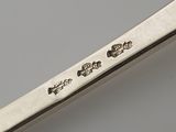 a silver spoon with writing on it sitting on a table
